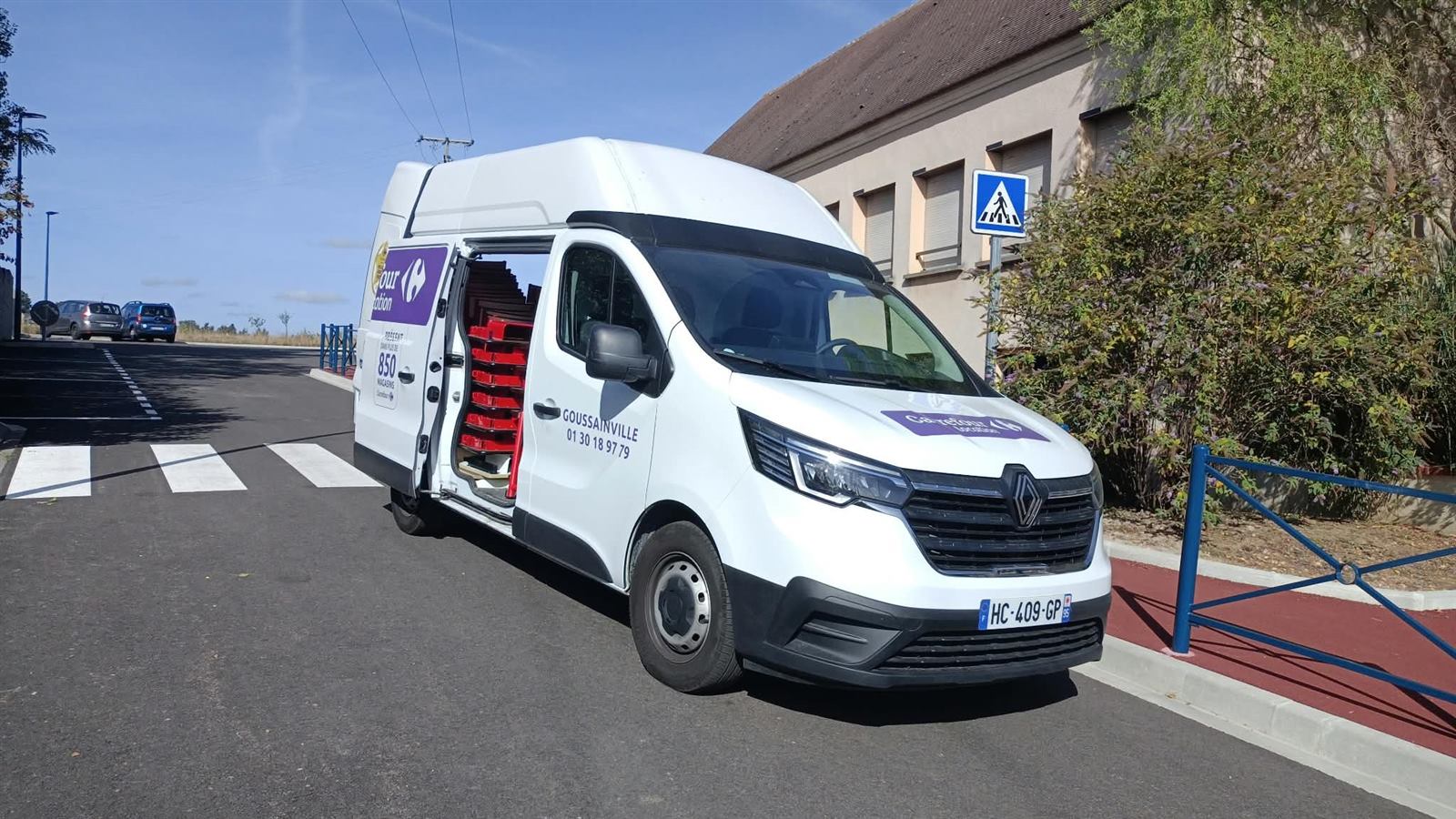La camionnette garée devant l'école, prête à repartir chargée du mobilier donné
