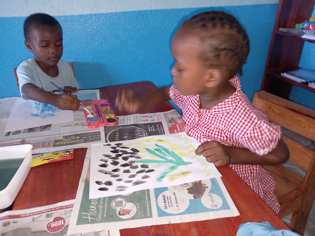 Enfants réalisant une activité de peinture en classe à la Maison des Enfants Lumières